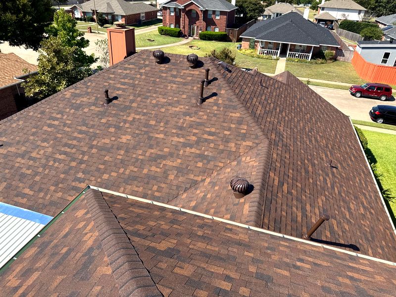 Autumn-brown architectural shingle roof with turbine vents on a North Texas home by Benchmark Roofing