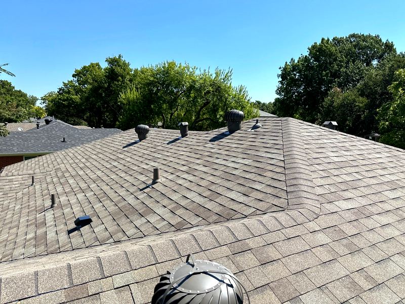 Weathered-wood toned asphalt shingle roof with turbine vents by Benchmark Roofing and Construction